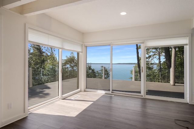 unfurnished sunroom featuring a water view