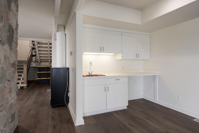 kitchen with dark hardwood / wood-style flooring, white cabinetry, and sink