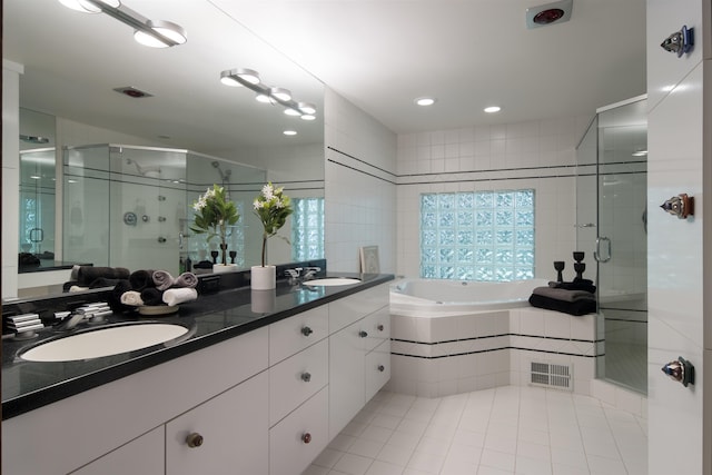 bathroom with plus walk in shower, vanity, and tile patterned flooring