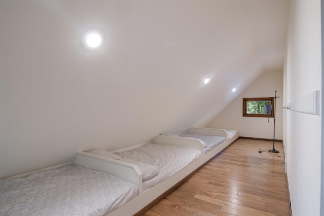 bedroom featuring light hardwood / wood-style floors and lofted ceiling