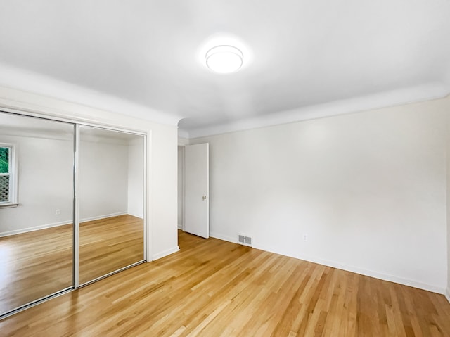 unfurnished bedroom with hardwood / wood-style flooring and a closet