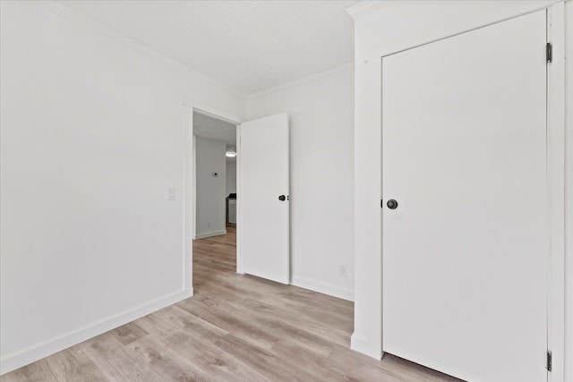 spare room featuring light hardwood / wood-style flooring and crown molding