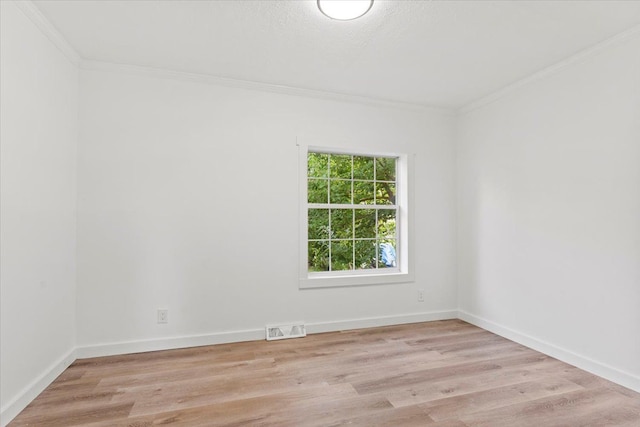 spare room with light wood-type flooring and ornamental molding