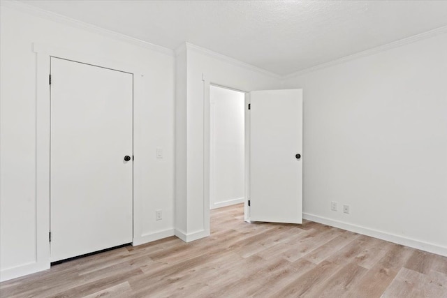 unfurnished bedroom featuring a textured ceiling, light hardwood / wood-style flooring, a closet, and crown molding