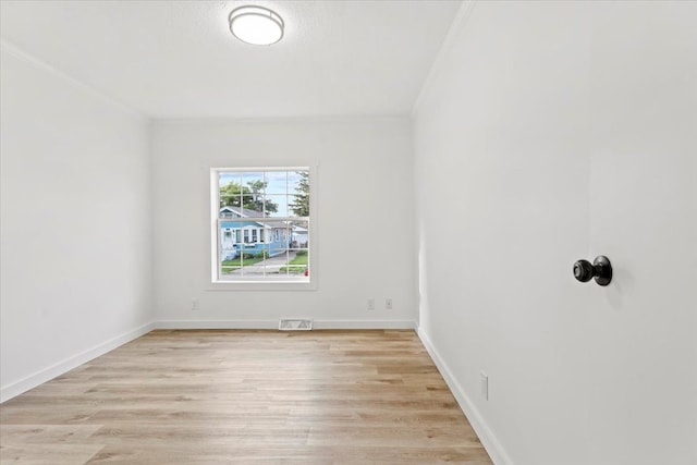 unfurnished room with light hardwood / wood-style flooring and crown molding