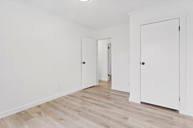 unfurnished bedroom featuring ornamental molding, a textured ceiling, and light wood-type flooring