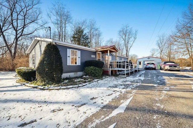 view of snowy exterior with an outdoor structure and a garage