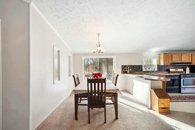 dining room featuring a notable chandelier, a healthy amount of sunlight, light colored carpet, and ornamental molding