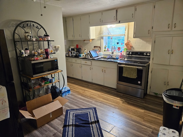 kitchen with appliances with stainless steel finishes, a textured ceiling, backsplash, and sink