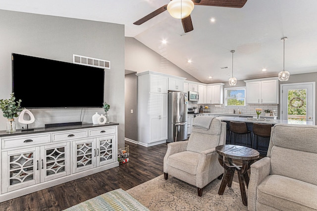 living room with ceiling fan, dark hardwood / wood-style flooring, and high vaulted ceiling