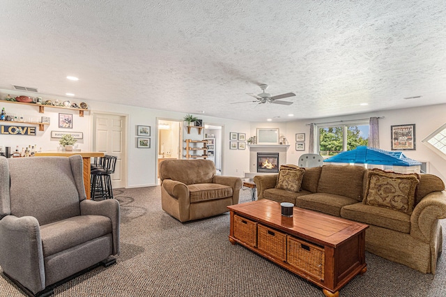 carpeted living room featuring ceiling fan and a textured ceiling