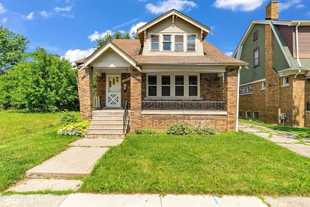 bungalow-style home with covered porch and a front yard