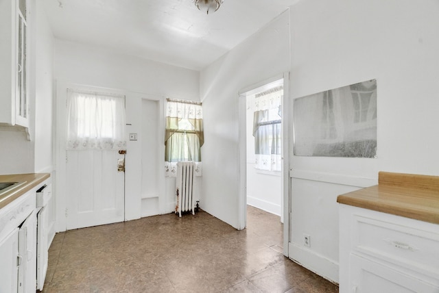 interior space with radiator and white cabinetry