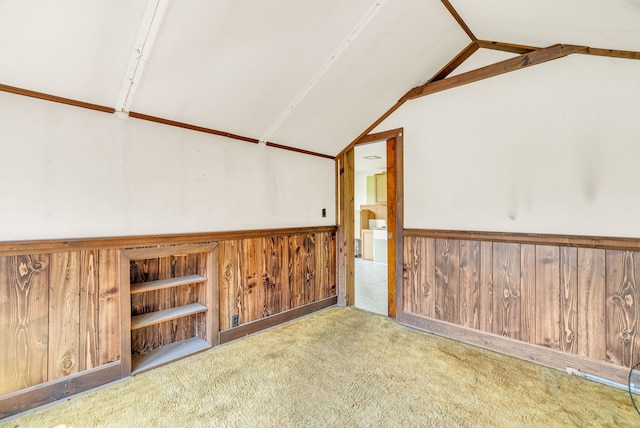 empty room with lofted ceiling, carpet floors, and wooden walls