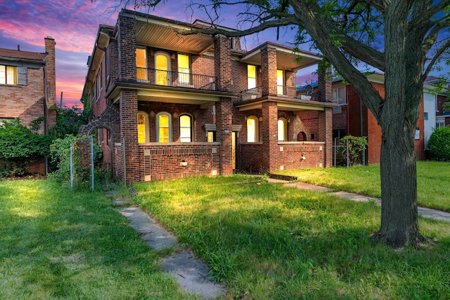 view of front of house featuring a yard and a balcony