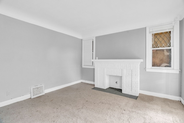 unfurnished living room featuring carpet flooring and a fireplace