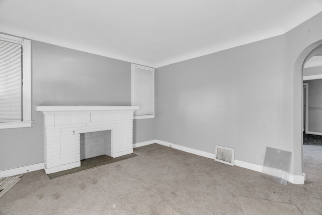 unfurnished living room featuring carpet flooring and a fireplace