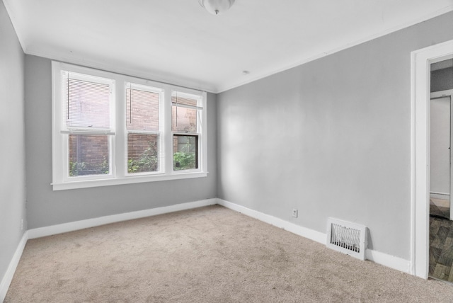 carpeted empty room featuring ornamental molding