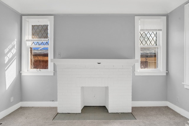 unfurnished living room with carpet, a fireplace, and a healthy amount of sunlight