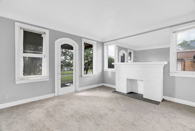 unfurnished living room with carpet floors and a fireplace