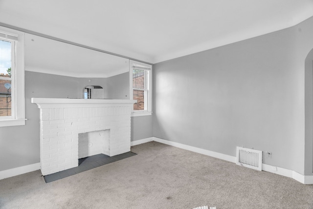 unfurnished living room with a fireplace and dark colored carpet