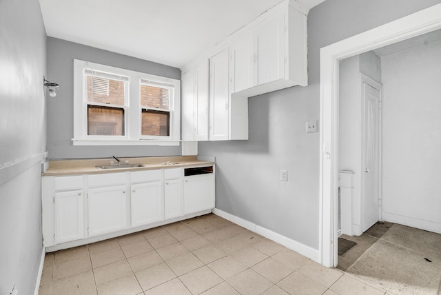 kitchen featuring white cabinets, light tile patterned floors, and sink