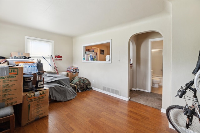 bedroom featuring ensuite bath and hardwood / wood-style floors