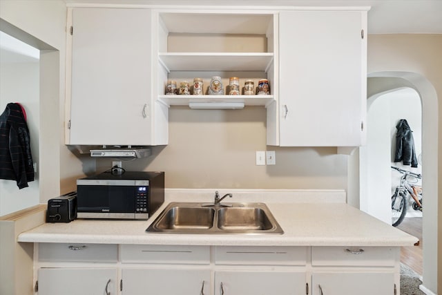 kitchen with white cabinets, sink, and hardwood / wood-style floors