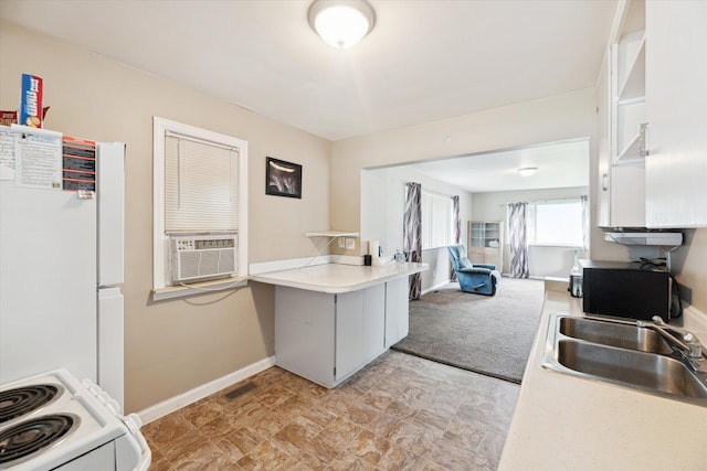 kitchen featuring kitchen peninsula, sink, cooling unit, and white appliances