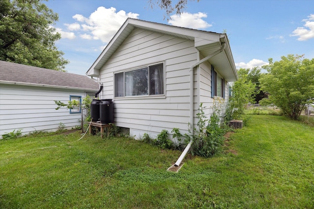 back of property featuring central AC and a yard