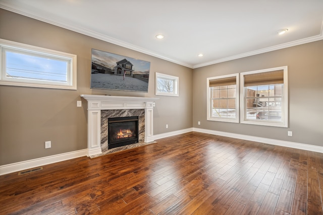 unfurnished living room with a premium fireplace, dark wood-type flooring, and ornamental molding