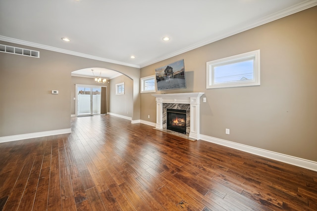 unfurnished living room with crown molding, a high end fireplace, and dark hardwood / wood-style floors