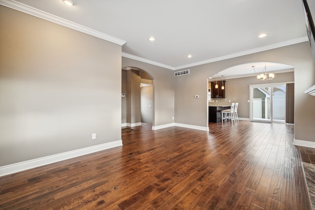 unfurnished living room featuring a chandelier, dark hardwood / wood-style flooring, and crown molding