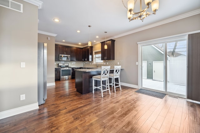 kitchen with dark hardwood / wood-style flooring, crown molding, and stainless steel appliances