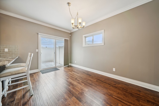 unfurnished dining area featuring dark hardwood / wood-style floors, an inviting chandelier, and crown molding