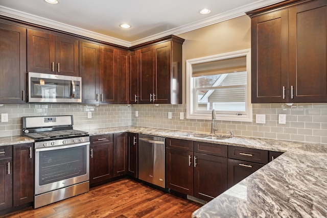 kitchen featuring sink, crown molding, dark hardwood / wood-style floors, appliances with stainless steel finishes, and light stone counters