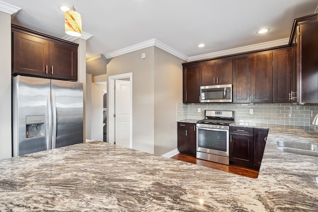 kitchen with pendant lighting, dark brown cabinets, sink, and appliances with stainless steel finishes