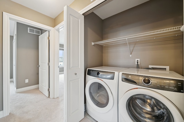 washroom featuring separate washer and dryer and light colored carpet