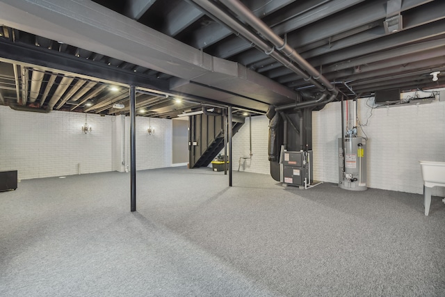 basement featuring carpet flooring, heating unit, brick wall, and water heater