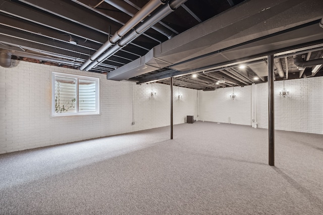 basement with carpet flooring and brick wall