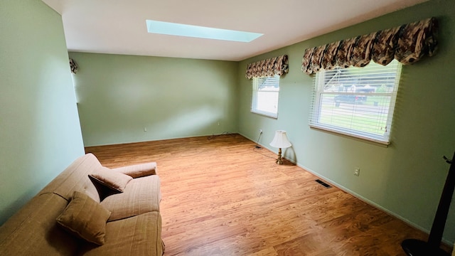 interior space featuring wood-type flooring and a skylight