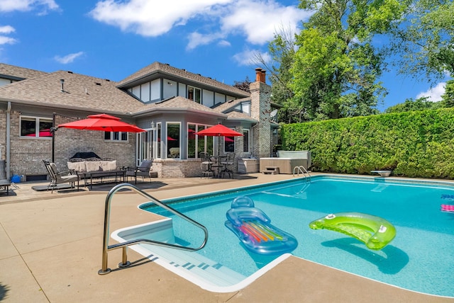 view of pool with a hot tub, an outdoor hangout area, a diving board, and a patio area