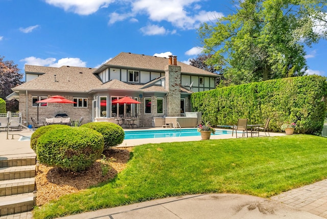 back of property featuring a patio, a fenced in pool, and a yard