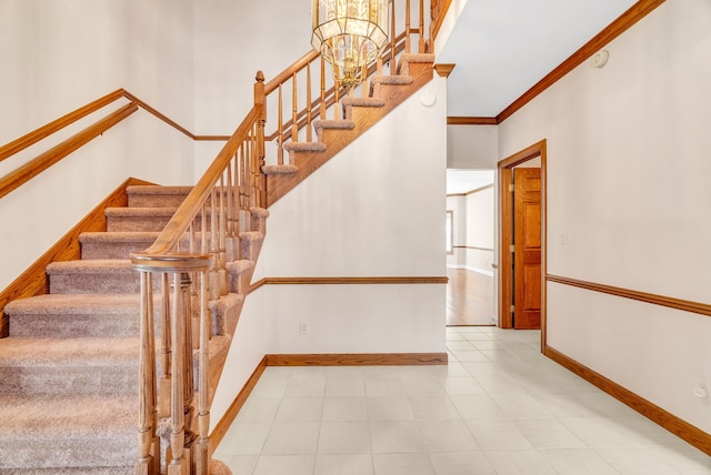 stairs with a chandelier and crown molding