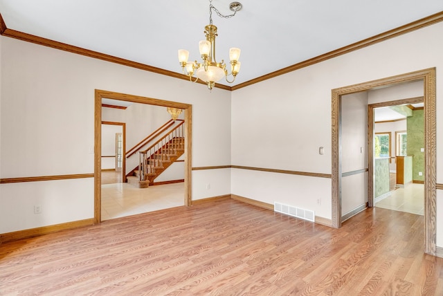 spare room with hardwood / wood-style flooring, ornamental molding, and a chandelier