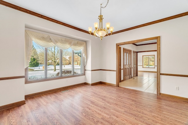 spare room featuring ornamental molding, light hardwood / wood-style flooring, and a chandelier