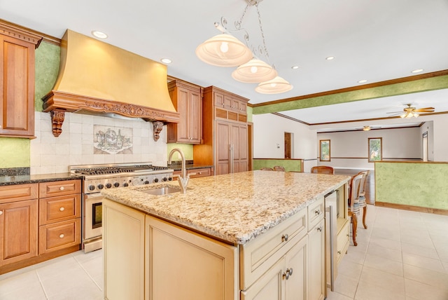 kitchen featuring premium appliances, an island with sink, custom range hood, tasteful backsplash, and crown molding