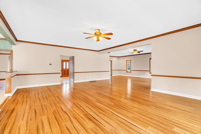 empty room with ornamental molding and light hardwood / wood-style floors