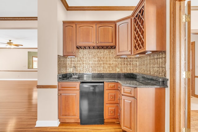 kitchen with sink, black dishwasher, ornamental molding, dark stone countertops, and ceiling fan