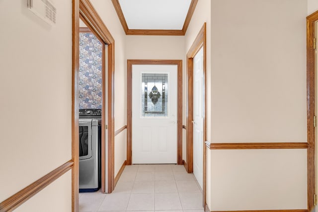 corridor featuring light tile patterned floors, ornamental molding, a wealth of natural light, and separate washer and dryer